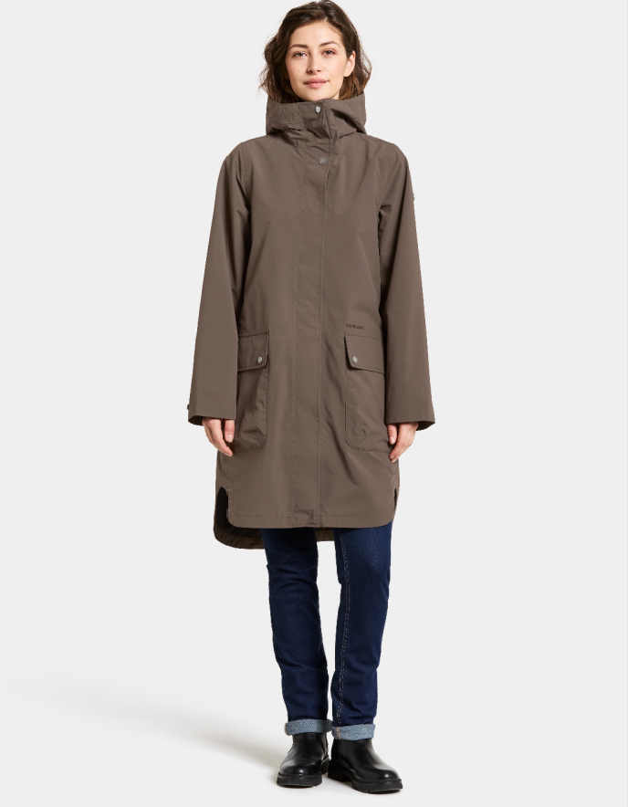 Woman wearing a mocha brown waterproof coat on a white background parka style