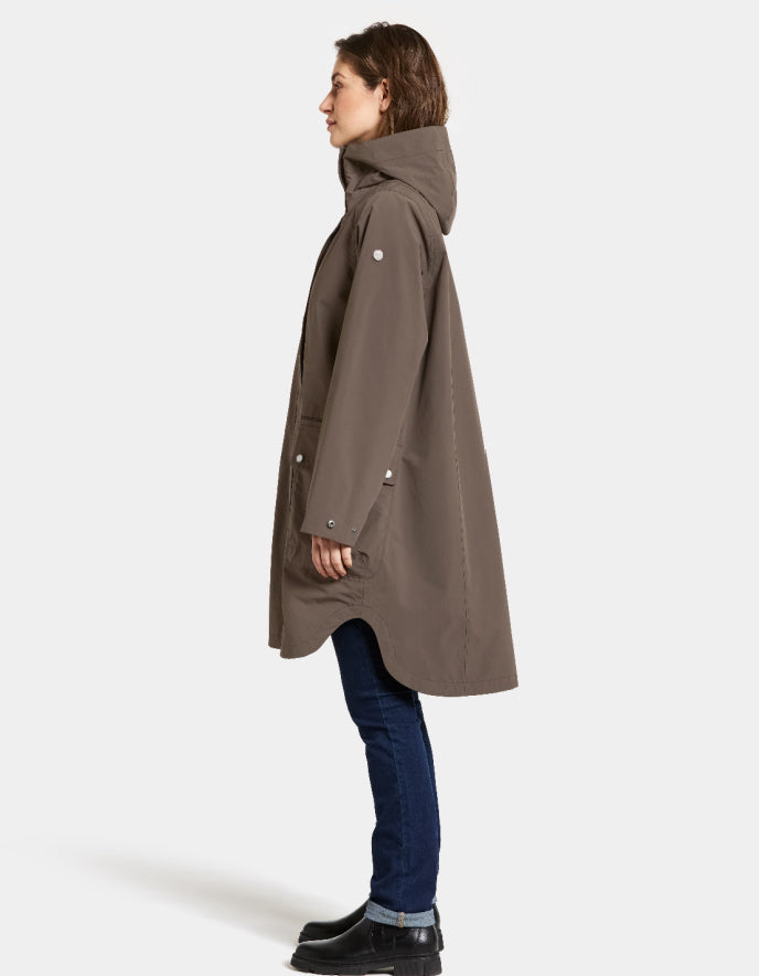 Woman wearing a mocha brown waterproof coat on a white background parka style