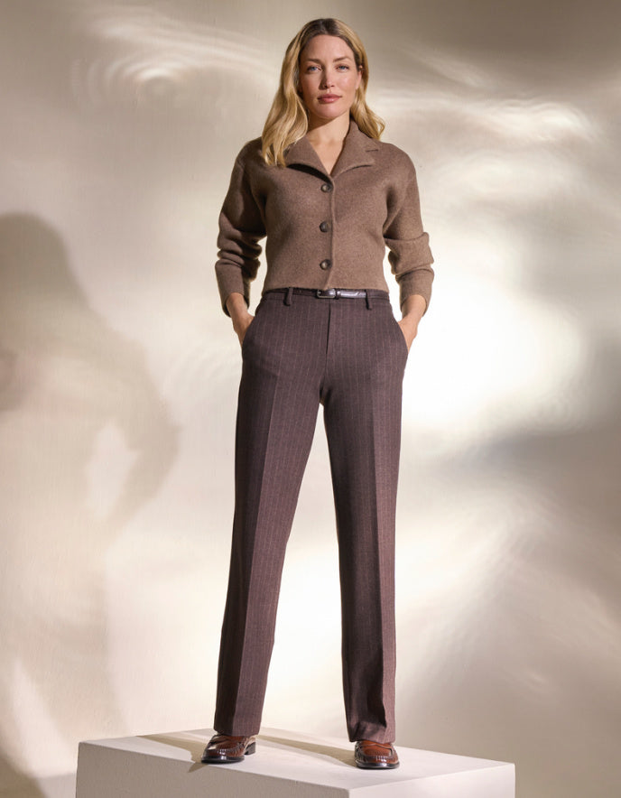 Brown pin stripe pants worn by a person on a white background