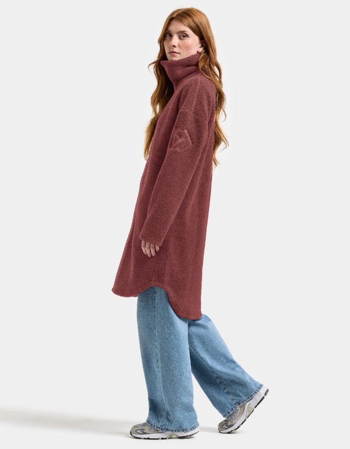 Woman wearing a long burgundy fleece sherpa pile coat on a white background jacket