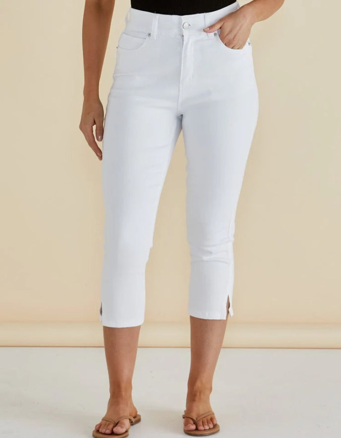 Person wearing white capri pants on a beige background