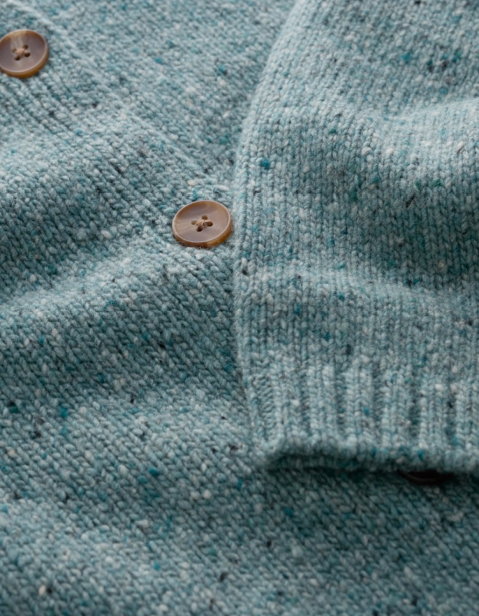 Close-up of a teal knitted cardigan with button details