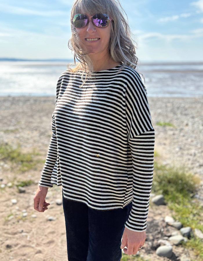 Woman wearing a black and white striped shirt on a beach