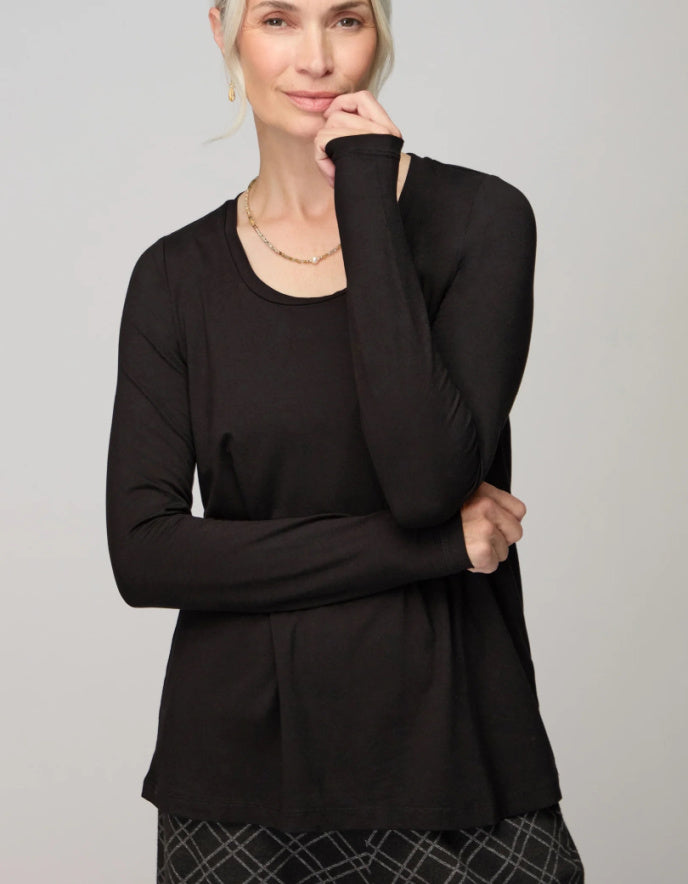 Woman wearing a black long-sleeve top against a plain background