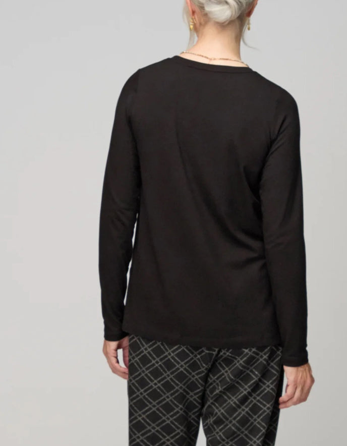 Person wearing a black long-sleeve shirt and plaid pants on a gray background