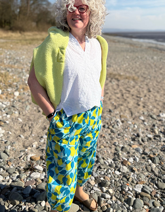 lantern shaped cotton summer trousers with apple print in turquoise and lime. elasticated waist and pockets and tie waist
