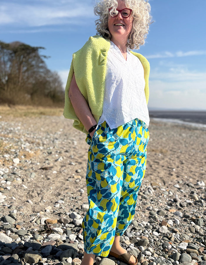lantern shaped cotton summer trousers with apple print in turquoise and lime. elasticated waist and pockets and tie waist