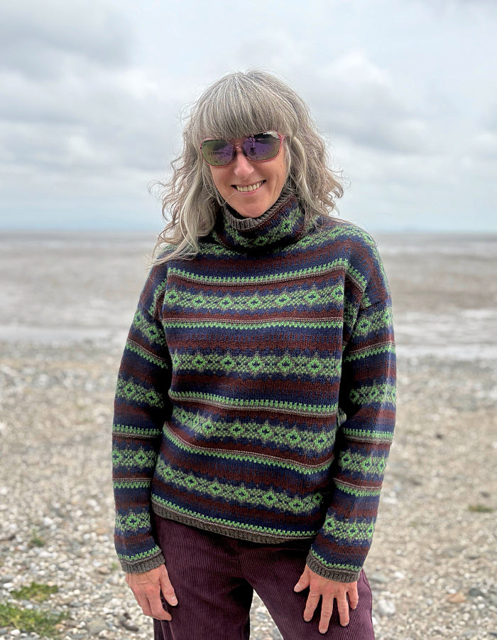 Person wearing a Fair Isle patterned sweater on a beach
