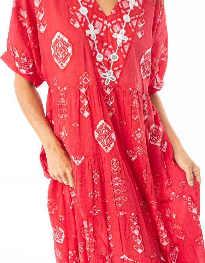 woman wearing red cotton boho dress with white patterns in Moroccan setting