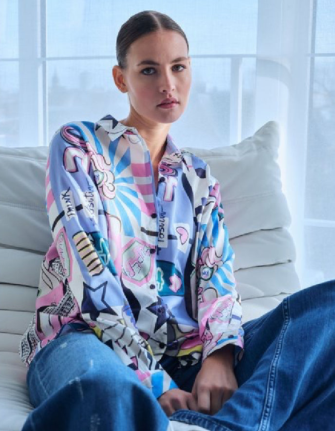 Person wearing a colorful patterned shirt sitting on a couch.