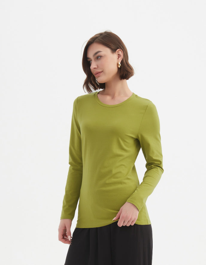 Woman wearing a green long-sleeve top on a white background