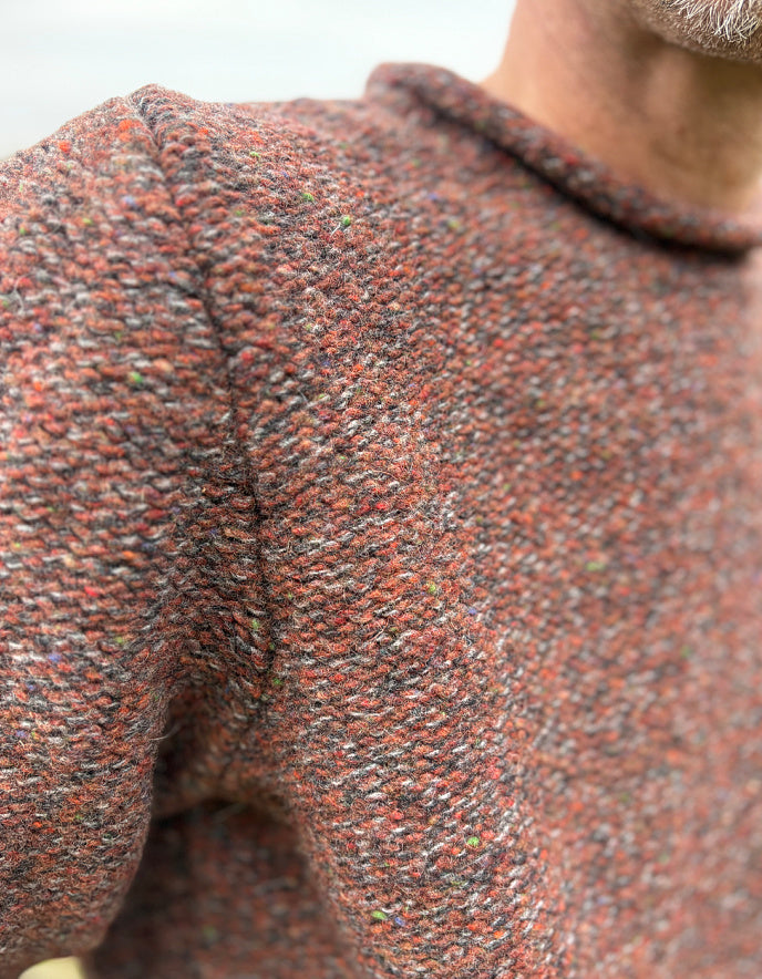 Close-up of a textured brown sweater with a blurred background