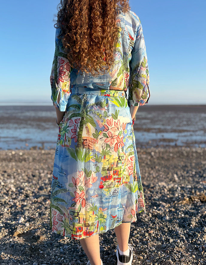 Person wearing a floral dress walking on a beach