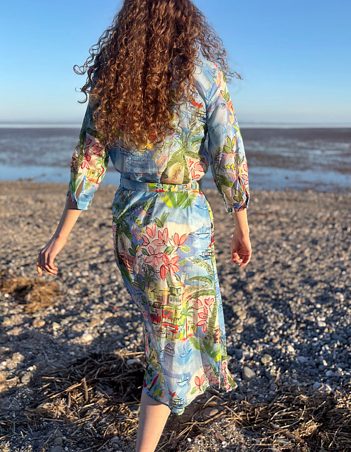 Person wearing a floral dress walking on a beach