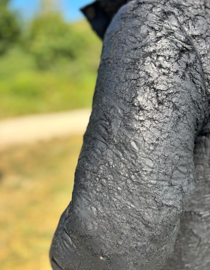 close up of black distressed fabric on a coat