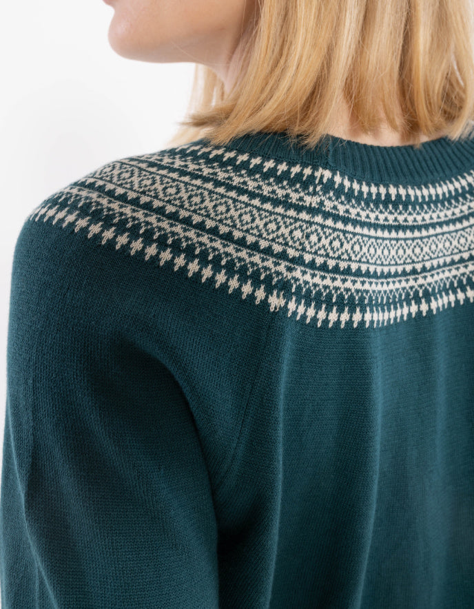 Teal sweater with white patterned neckline worn by a person