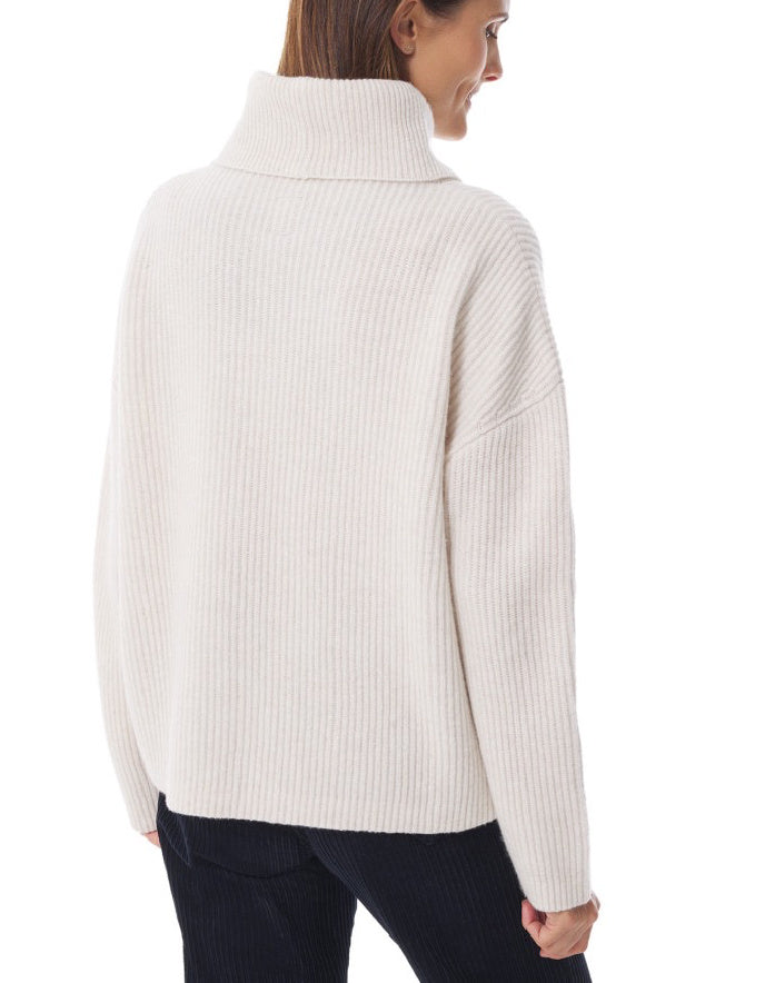 Woman wearing a white ribbed sweater on a white background