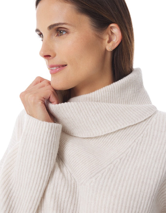 Woman wearing a beige turtleneck sweater on a white background