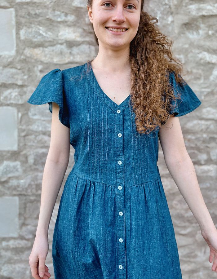 knee length denim dress with neckline, button through at the front and fluted sleeves, gathered waist. everyday dress