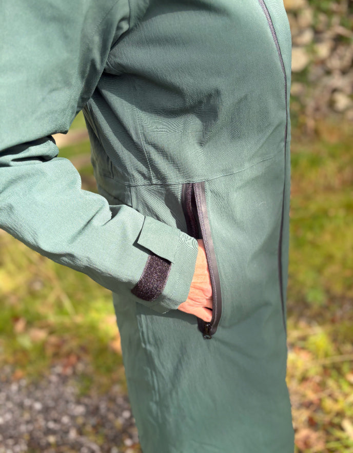 Close-up of a green raincoat with a blurred natural background