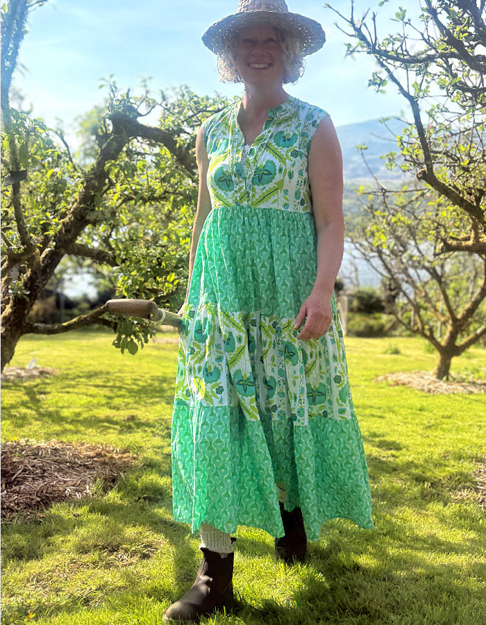 maxi length tiered sleeveless dress with a 70's retro vibe with a green and lime graphic floral print