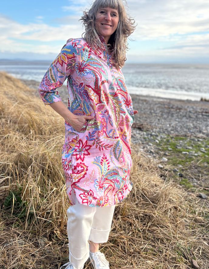 woman wearing a rose print cotton shirt dress over cream jeans