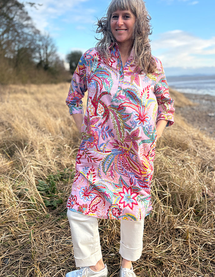 woman wearing a rose print cotton shirt dress over cream jeans