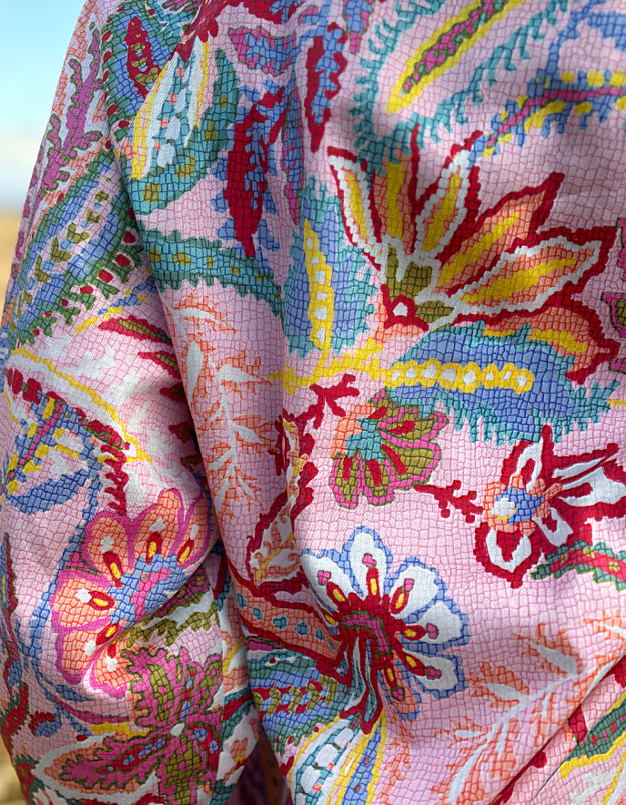 woman wearing a rose floral cotton blouse with white summer jeans