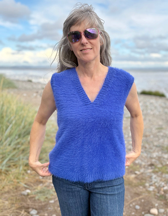 woman wearing cobalt blue fluffy V neck tank top and jeans