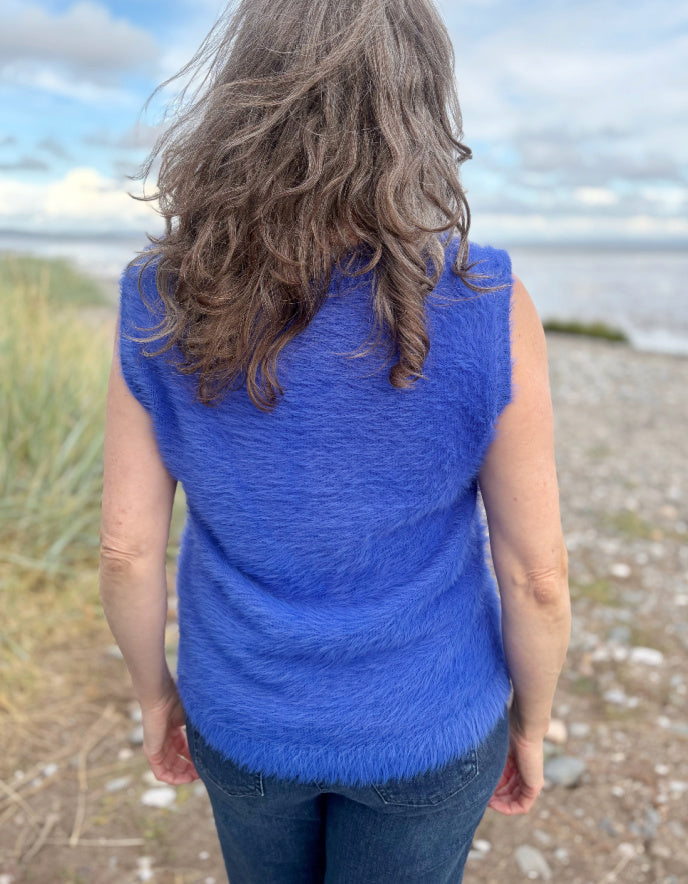 woman wearing cobalt blue fluffy V neck tank top and jeans