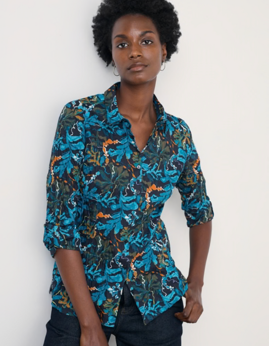 Woman wearing a blue floral patterned shirt against a white background