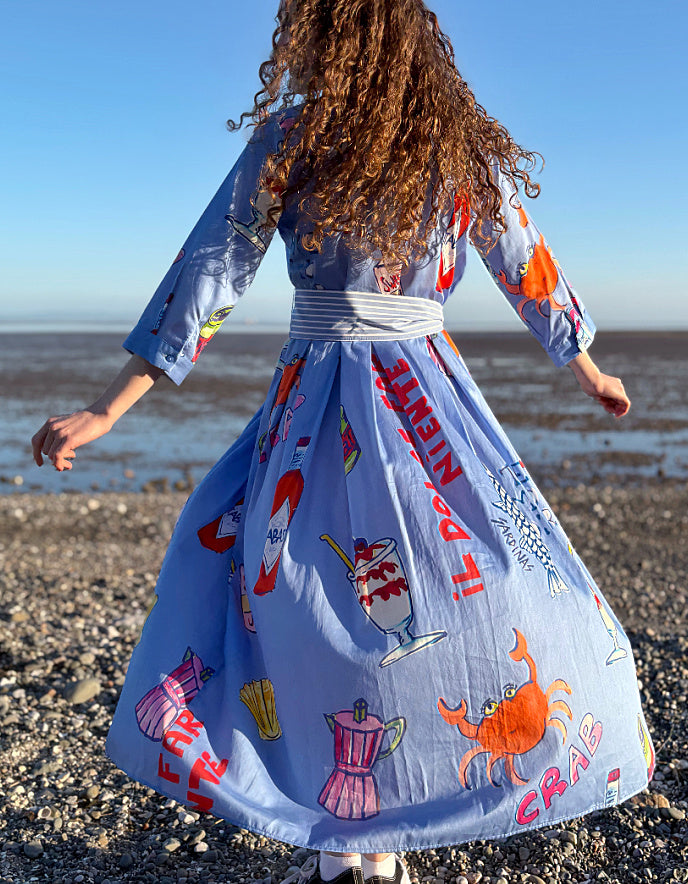 Person wearing a colorful dress with graphics on a beach