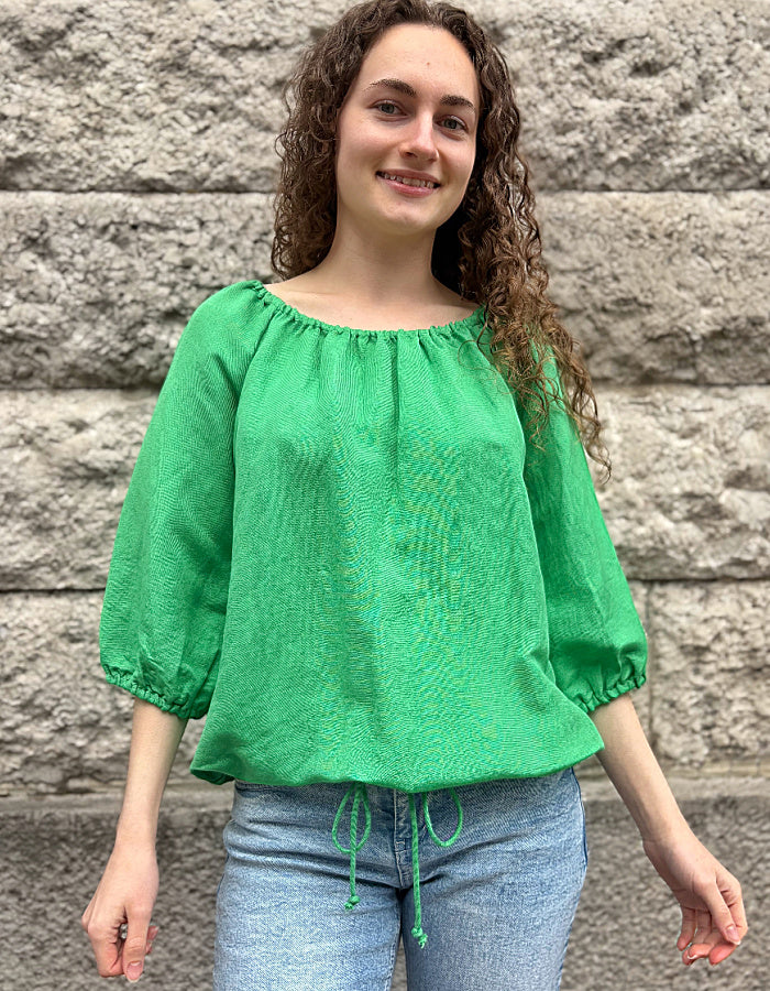 green linen top with elasticated scoop neckline that can be worn off shoulder and adjustable was it. with 3/4 length sleeves