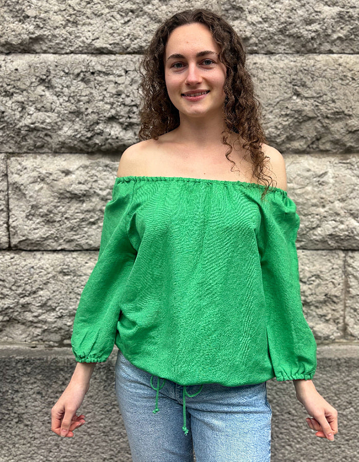 green linen top with elasticated scoop neckline that can be worn off shoulder and adjustable was it. with 3/4 length sleeves
