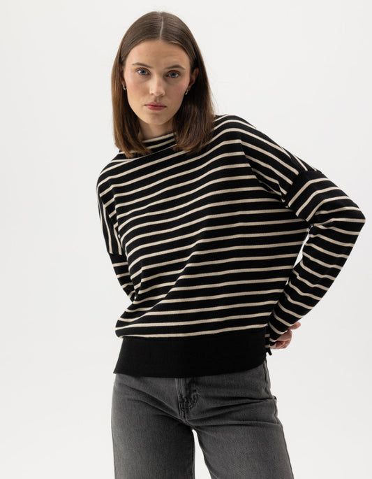 Woman wearing a navy and cream striped cottonsweater on a white background