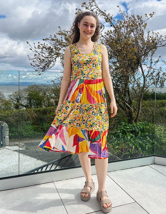 sleeveless cotton sundress with bright coloured print in collage style, tiered skirt and two front patch pockets
