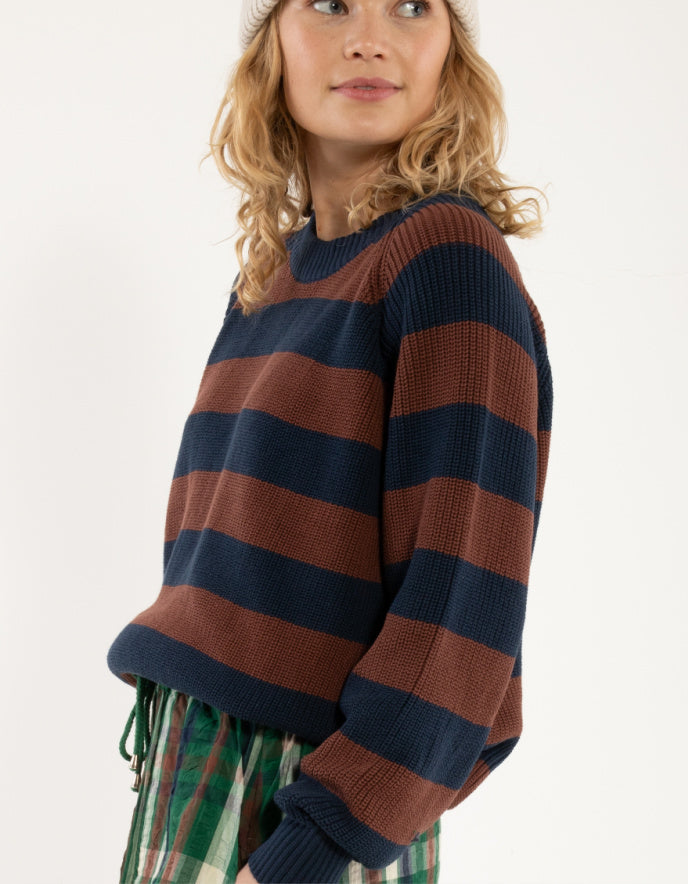 Woman wearing a striped sweater with a white background