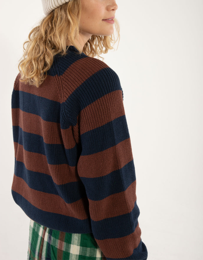 Person wearing a striped sweater with a neutral background