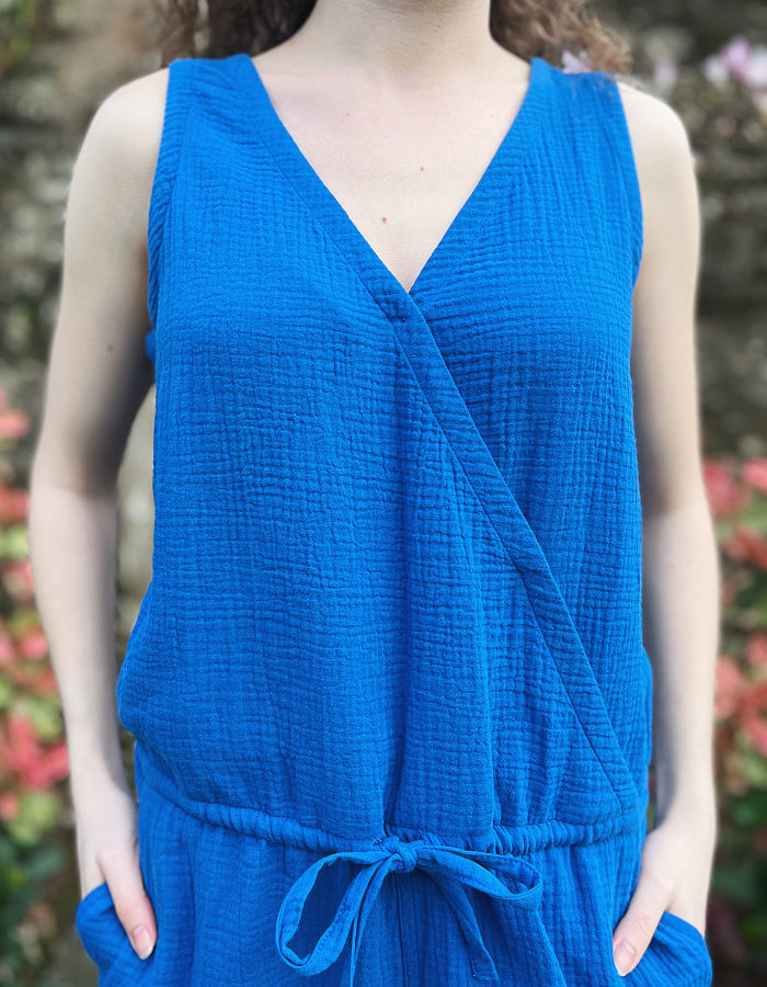 cotton short jumpsuit with cross over front panel and front and rear pockets and adjustable drawstring waist in gauzy cheesecloth blue cotton