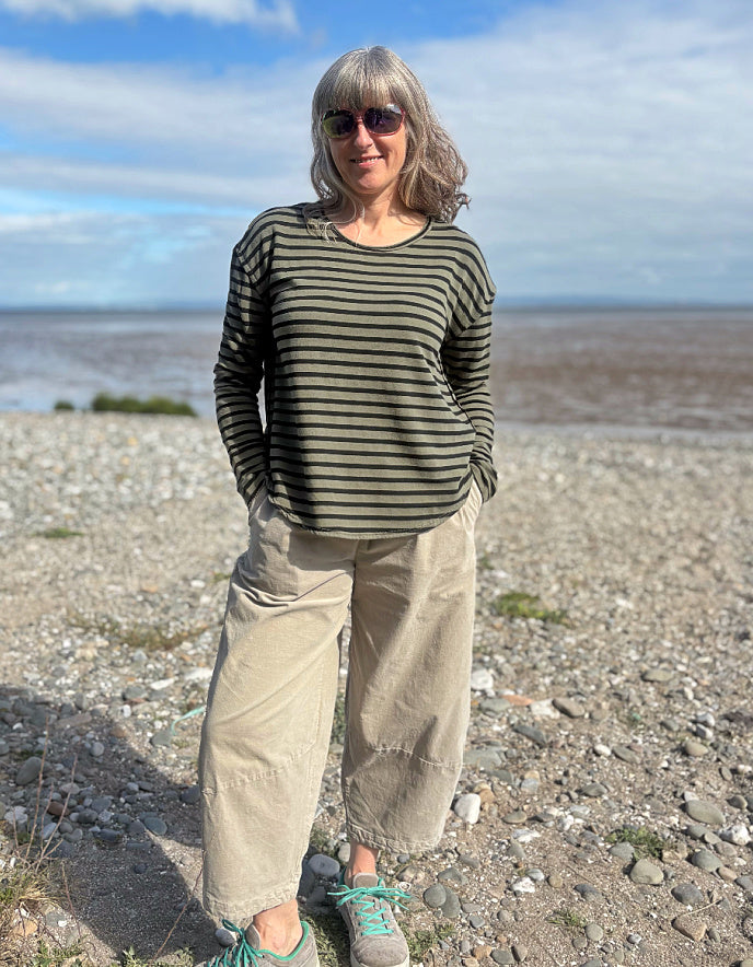 Woman wearing a striped shirt fleece t shirt and sunglasses on a beach