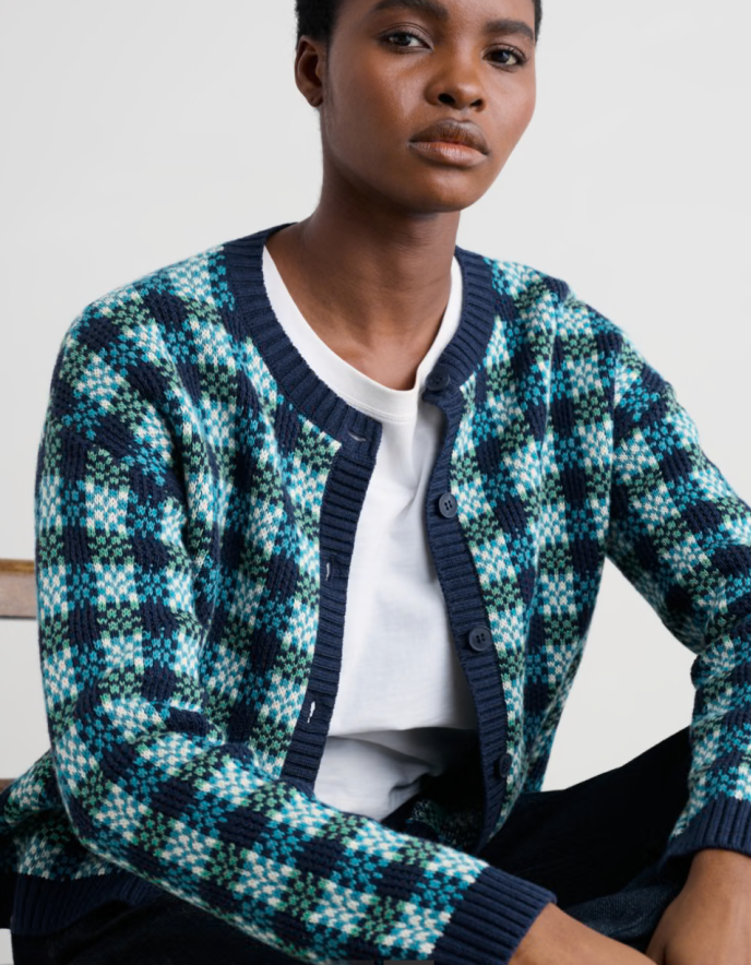 Person wearing a blue and green patterned cotton cardigan over a white shirt.