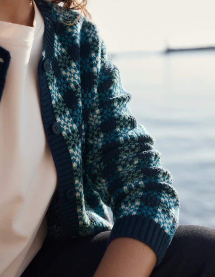 Person wearing a blue and green patterned cotton cardigan over a white shirt.