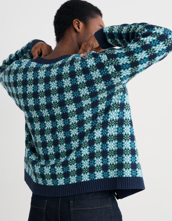 Person wearing a blue and green patterned cotton cardigan over a white shirt.