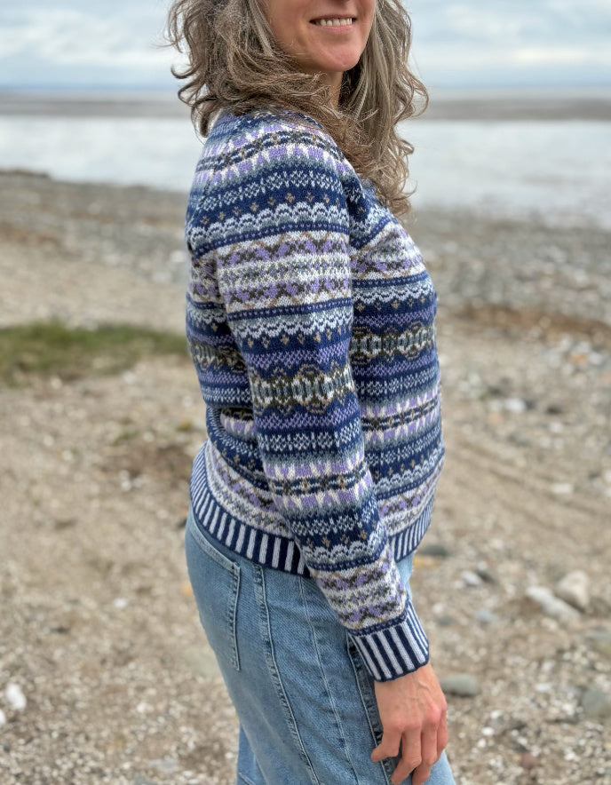 Woman wearing a blue fair isle patterned cardigan and jeans