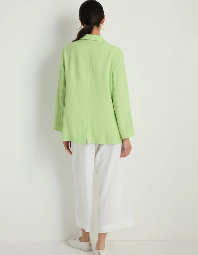 Person wearing a light green jacket and white pants on a white background