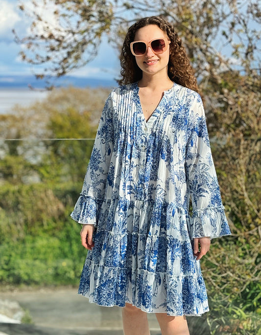 cotton tiered dress with toile like blue stitch print, full length sleeve with frilled edges