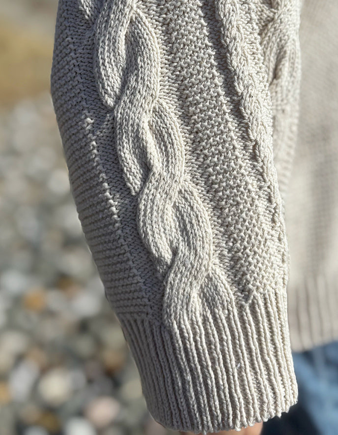 woman wearing cotton cable sweater on a beach