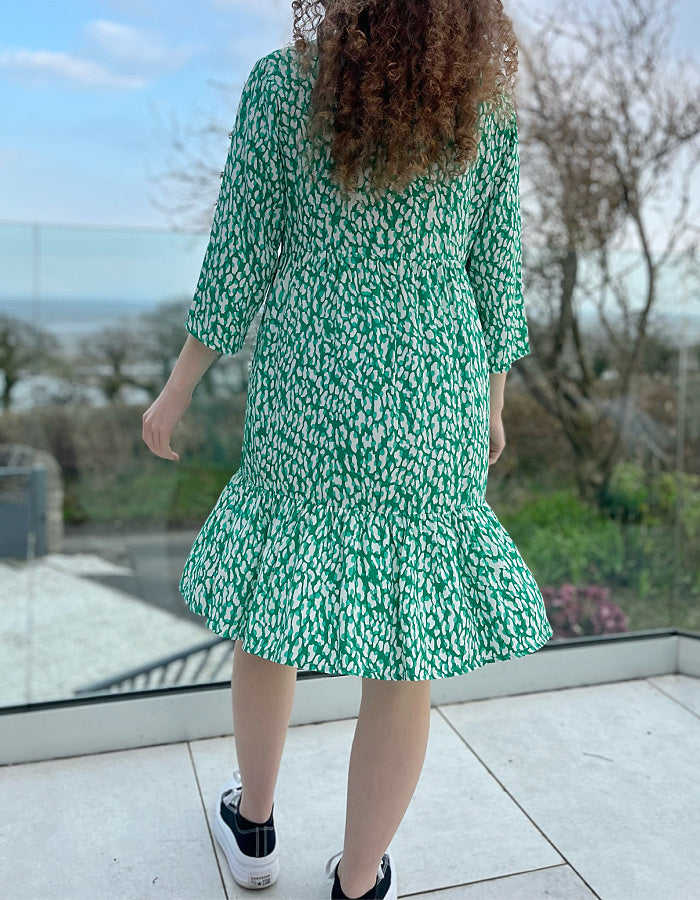 knee length loose fit summer dress in white and fresh green abstract print, 3/4 sleeves and frilled hemline