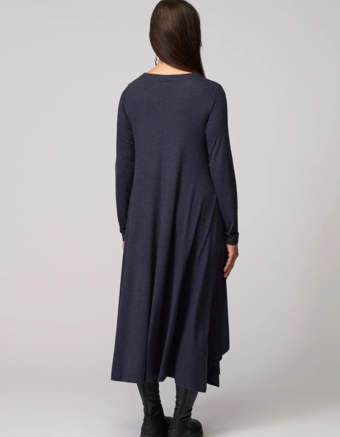 Woman wearing a long dark blue dress against a white background