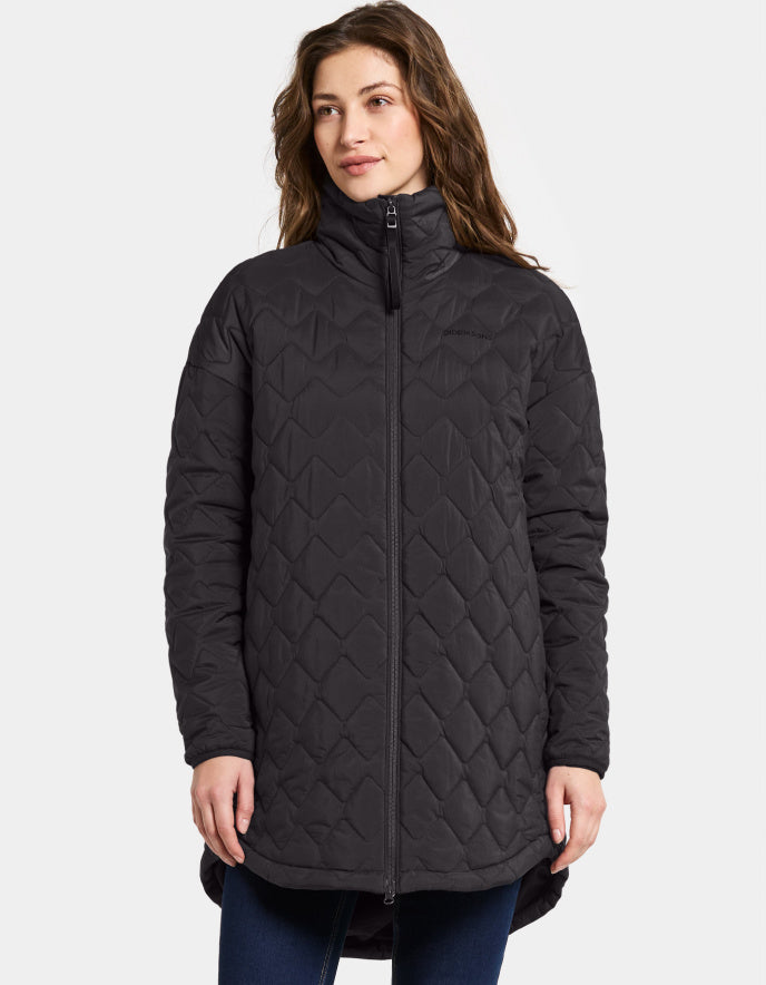 Woman wearing a black quilted jacket on a white background